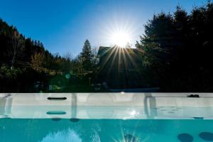 a swimming pool with the sun in the background at Chalet Cotes du Lavancher in Chamonix-Mont-Blanc