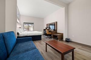 a living room with a couch and a bed and a table at Clarion Pointe Lakeland I-4 in Lakeland