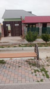 a park bench sitting in front of a building at Top in Türkistan