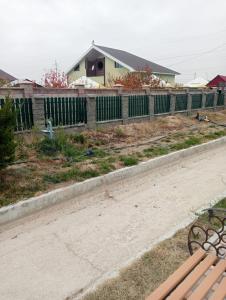 a park bench sitting next to a fence at Top in Türkistan