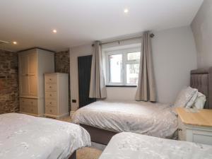比迪福德The Cottage的有两张床和一扇窗户的卧室