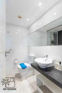 a white bathroom with a sink and a toilet at Hola Jag Corralejo Center iRent Fuerteventura in Corralejo