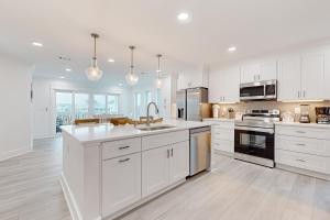 a large white kitchen with white cabinets and appliances at Bahia Beauty - 3rd Floor in Navarre