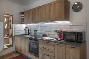 a kitchen with wooden cabinets and a microwave and a sink at Annì in Temù