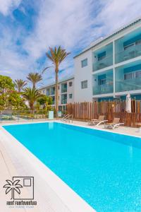 a swimming pool in front of a building at Hola Jag Corralejo Center iRent Fuerteventura in Corralejo