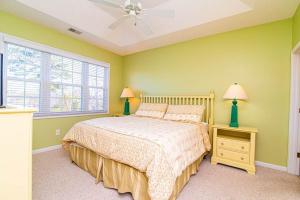 a bedroom with a bed with green walls and a window at Lakefront and 1 Block to Beach! Walk to Main St in Myrtle Beach +50 photos