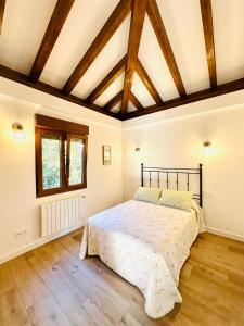 a bedroom with a bed and a wooden floor at Apto Pedreña Golf y Surf in Pedreña