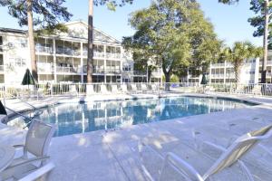 a swimming pool with chairs and a building at Lakefront and 1 Block to Beach! Walk to Main St in Myrtle Beach