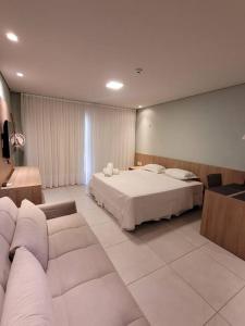 a hotel room with a bed and a couch at BobZ Villas - Bora Bora 102 in Cajueiro