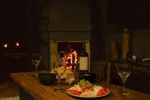 a table with a plate of food and wine glasses at Surfway Ilha do Mel in Ilha do Mel