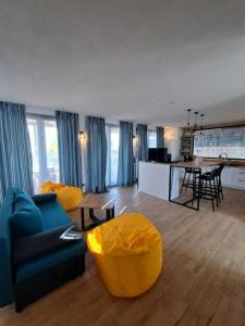 a living room with a blue couch and a kitchen at 3-Bedroom Villa in Lozenets, Burgas, Bulgaria in Lozenets