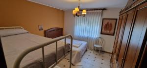 ein Schlafzimmer mit einem Bett und einem Stuhl darin in der Unterkunft La Casona de Cangas - Para 12 pax - VV-3200-AS in Cangas de Onís