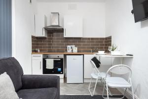 a kitchen with a refrigerator and a table and chairs at Velvet Coaster Apartments in Blackpool