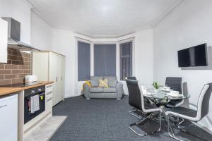 a kitchen and living room with a table and chairs at Velvet Coaster Apartments in Blackpool