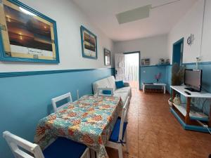 una habitación con una cama y una mesa y un televisor en Apartamentos Buen Leon, en Playa de Tasarte