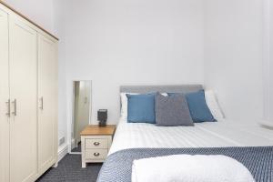 a bedroom with a large bed with blue pillows at Velvet Coaster Apartments in Blackpool