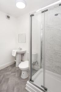 a white bathroom with a toilet and a sink at Velvet Coaster Apartments in Blackpool