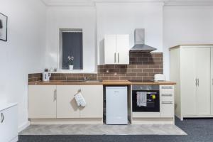 a kitchen with white cabinets and a counter top at Velvet Coaster Apartments in Blackpool