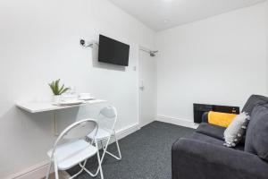 a living room with a couch and a table and chairs at Velvet Coaster Apartments in Blackpool