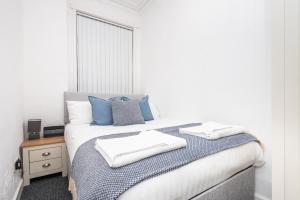 a bedroom with a bed with two towels on it at Velvet Coaster Apartments in Blackpool +28 photos