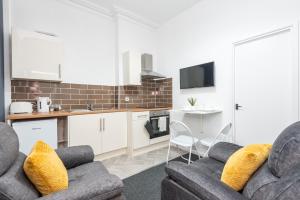 a living room with two couches and a kitchen at Velvet Coaster Apartments in Blackpool