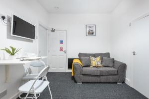 a living room with a chair and a couch and a desk at Velvet Coaster Apartments in Blackpool