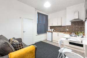 a kitchen and living room with a couch and a table at Velvet Coaster Apartments in Blackpool