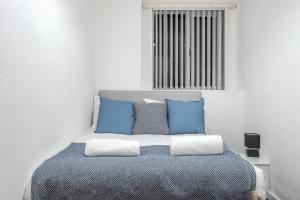 a bedroom with a bed with blue and white pillows at Velvet Coaster Apartments in Blackpool