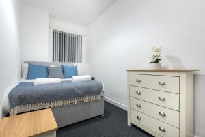 a small bedroom with a bed and a dresser at Velvet Coaster Apartments in Blackpool
