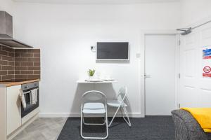 a small kitchen with a table and chairs in a room at Velvet Coaster Apartments in Blackpool