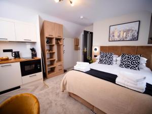 a bedroom with a large bed and a kitchen at Apart Hotel Rugby -Self Check In- in Rugby