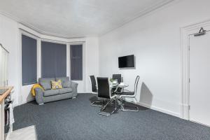 a living room with a couch a chair and a table at Velvet Coaster Apartments in Blackpool
