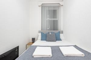 a bedroom with a bed with blue pillows at Velvet Coaster Apartments in Blackpool