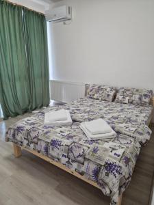 a bed with two towels on it in a room at Lovely 1-room apartment self check-in in Popeşti-Leordeni