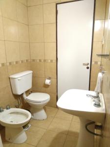 a bathroom with a toilet and a sink at Alojamiento Avellaneda in Rosario +30 photos