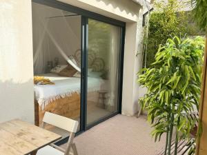 a glass door leading to a bedroom with a bed at Le cocon de sissy in Saintes-Maries-de-la-Mer