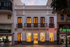 a white building with lights in the windows at Panasco Real Suite - Panasco Suites in Arrecife