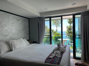 a bedroom with a bed and a large window at Cliff Lanta Suite-Koh Lanta Krabi in Ko Lanta