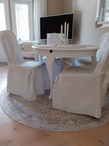a white table with two white chairs and a table with candles at Ferienwohnung Benvenuto in Bad Harzburg