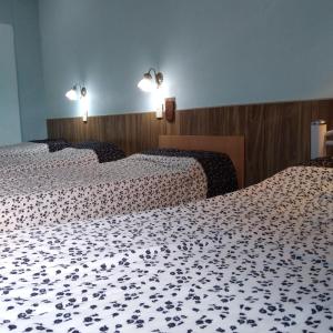 two beds in a hotel room with white sheets at Alojamiento Avellaneda in Rosario