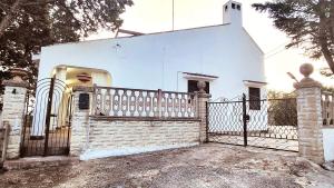 a white house with a gate and a fence at Villa Isabella - Guest House in Ostuni