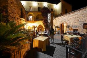 a group of people sitting at tables in a restaurant at Palazzo dei Poeti in Tursi