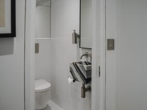 Un baño blanco con inodoro y lavabo. en Lower Court House, en Salcombe