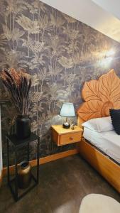 Un dormitorio con una cama y una mesa con una lámpara. en Pension Paloma - Oiartzun, en Oiartzun