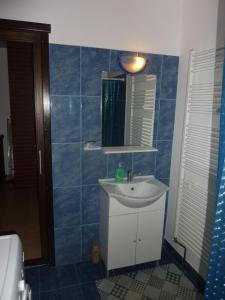 a bathroom with a sink and a mirror at Casuta de pe deal in Băiculeşti