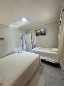 a room with two beds and a painting on the wall at Riviera Flat 120 - Com serviços de hotelaria in Riviera de São Lourenço +43 photos