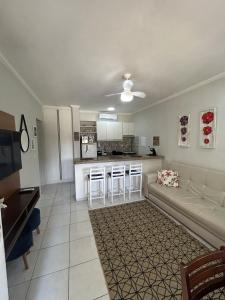 a living room with a couch and a kitchen at Riviera Flat 120 - Com serviços de hotelaria in Riviera de São Lourenço