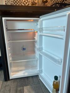 Un refrigerador vacío con la puerta abierta en una cocina. en LE VICTORIA, en Besançon