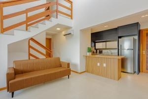 un soggiorno con divano e cucina di GB112 - Belo Apartamento Duplex 4 suítes - Guarajuba a Monte Gordo