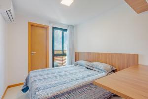 una camera da letto con un letto, un tavolo e una finestra di GB112 - Belo Apartamento Duplex 4 suítes - Guarajuba a Monte Gordo Altre 31 foto